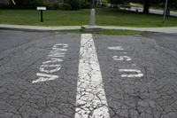 Painted markings on a roadway indicating Canada on one side of a line and USA on the other side