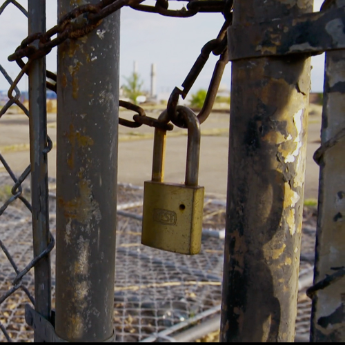 Gate chained closed with a lock held on by a broken carabiner